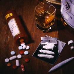 Tableau of drugs- pills, coke, marijuana, and alcohol.